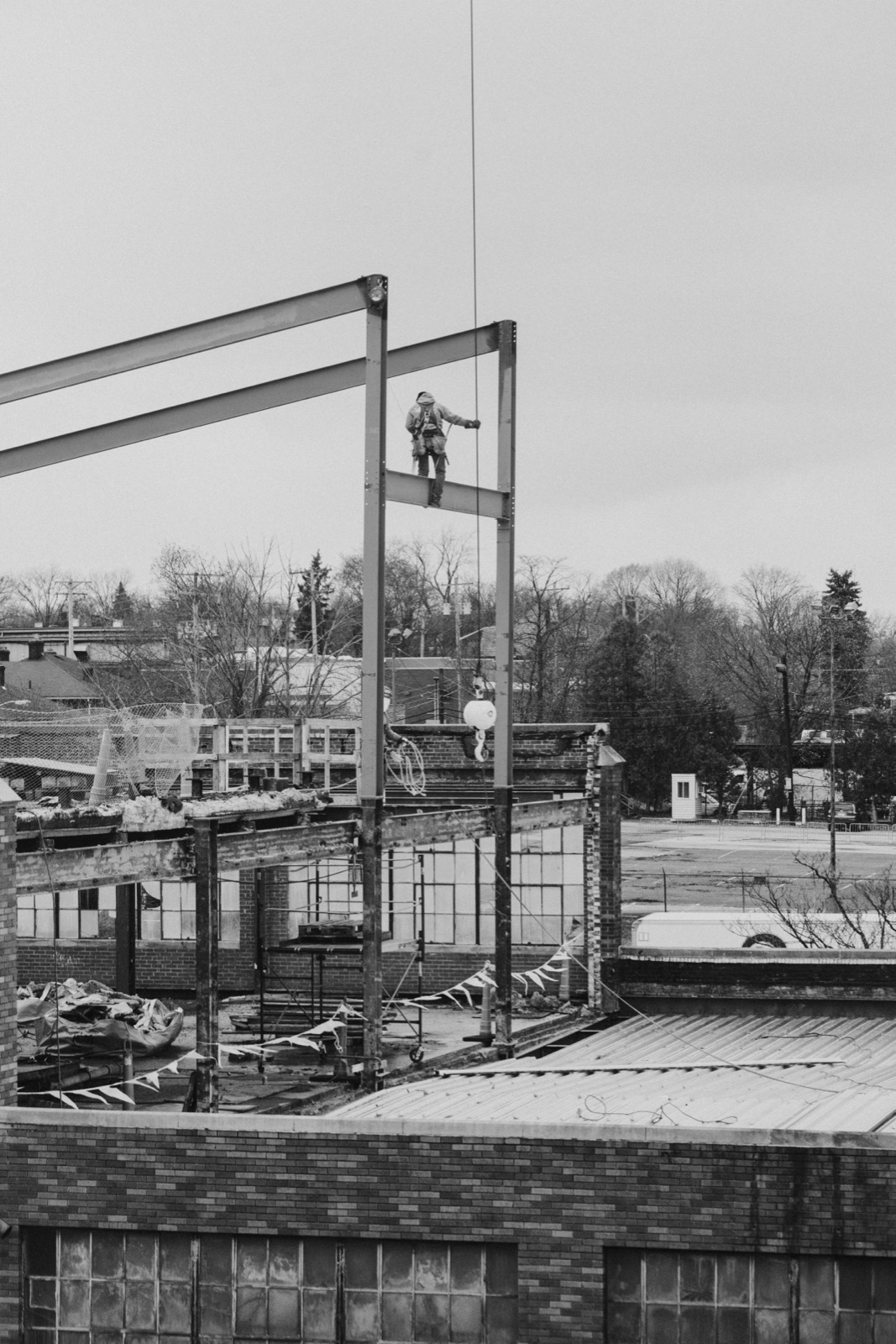 An ironworker raising the new sawtooth roof steel over the Edwin